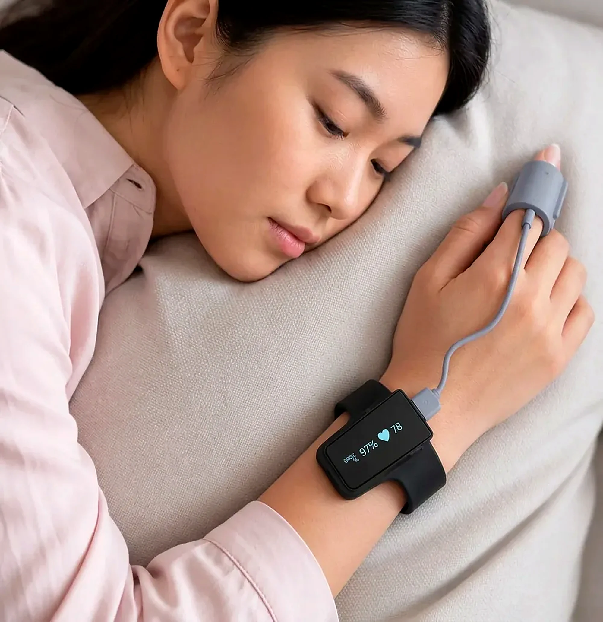 A woman asleep wearing VitalWeave Sleep with a finger sensor